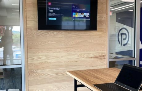 Wood paneled wall with mounted tv in an office setting